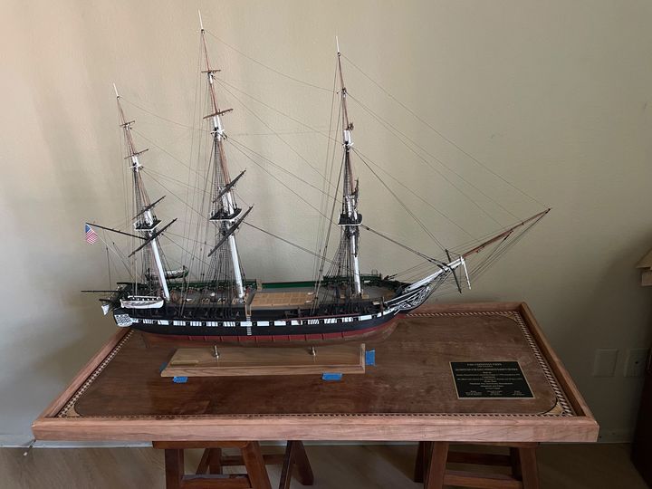 The model on its custom wooden display table with an engraved plaque