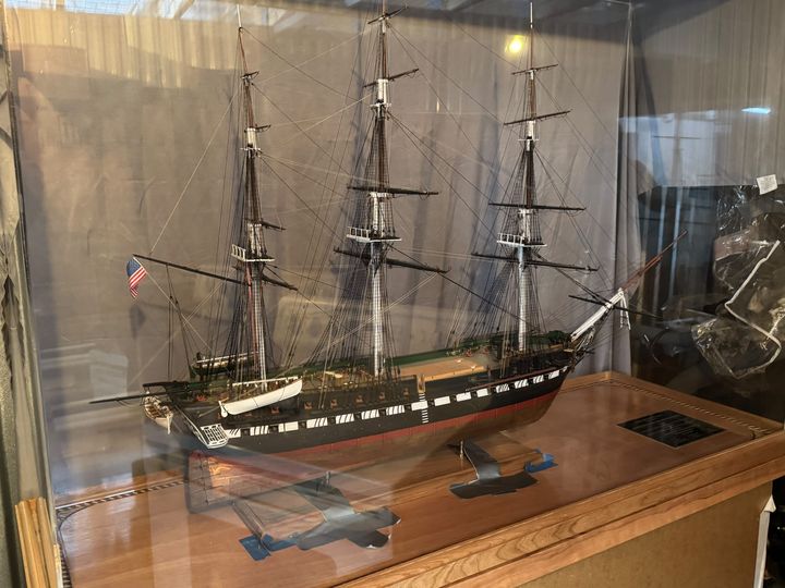 The model under its acrylic display cover on the wooden table