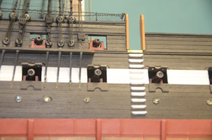 The side of the hull, with gun ports, channels with deadeyes, and side steps