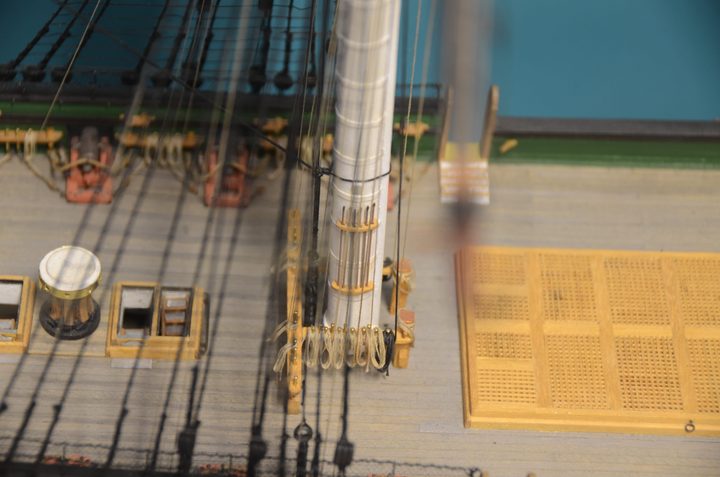 The base of a mast, with the fife rail, a hatch grating, and the capstan